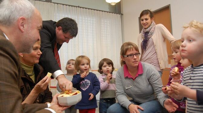 Ein Apfelschmaus Aug' in Aug' mit dem Politbesuch: Kita-Kinder und (von links) Landrat Thomas Reumann, Staatssekretärin Friedlin