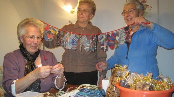 Gretel Federschmid, Inge Eißler und Annefriede Bächle: Sie halten einen Adventskalender, der aus 24 kleinen Söckchen gestrickt w