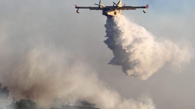 Ein griechisches Löschflugzeug lässt Wasser auf das Dorf Ein Hod nahe Haifa fallen. 