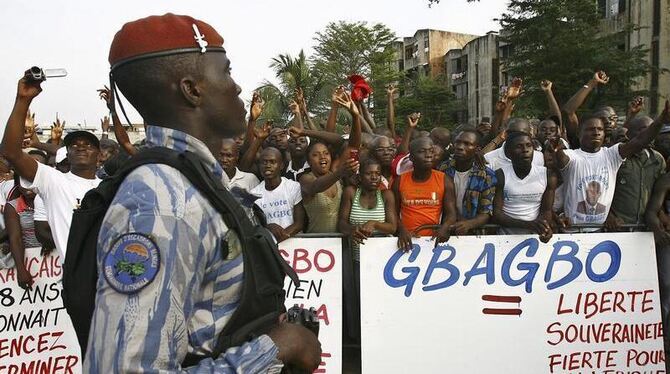 Ein ivorischer Polizist beobachtet eine Pro-Gbagbo-Demonstration in Abidjan.