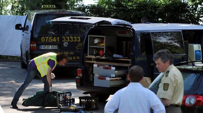 Ein Beamter der Kriminalpolizei steht am 09.06.2010 in Hagnau am Bodensee vor dem Wagen einer ermordeten Taxifahrerin.