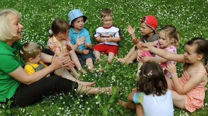 In einem Kindergarten singen Kinder mit der Erzieherin: Das Bundesumweltministerium will Klagen wegen Kinderlärms erschweren.