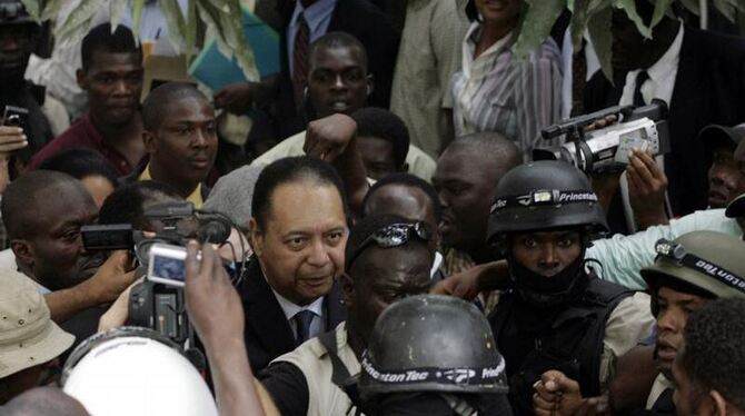 Ex-Diktator Jean-Claude Duvalier umringt von Polizisten und Fotografen.