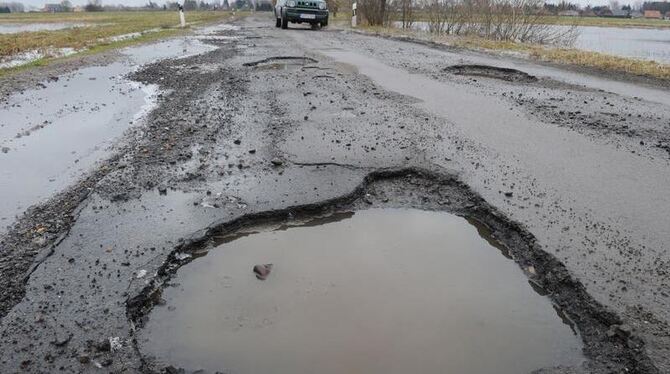 Ein tiefes Schlagloch auf einer Kreisstraße.