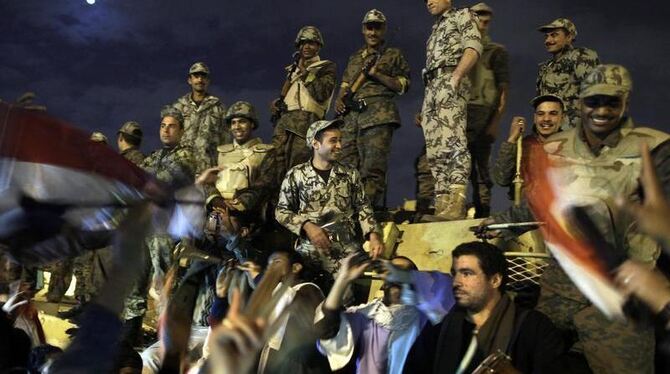 Ägypter feiern den Mubarak-Rücktritt zusammen mit Soldaten auf dem Tahrir-Platz.