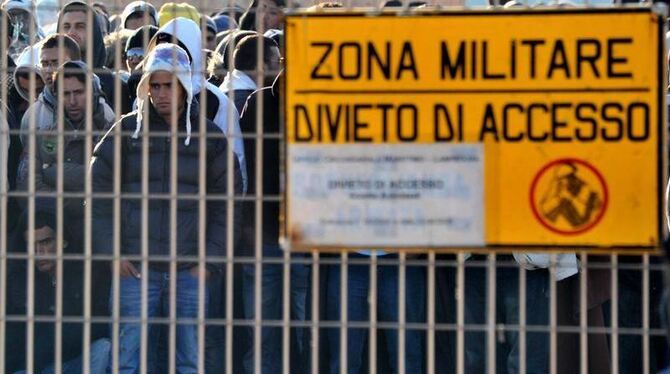 Tunesische Flüchtlinge in einer militärischen Sperrzone nach der Ankunft auf der süditalienischen Insel Lampedusa.