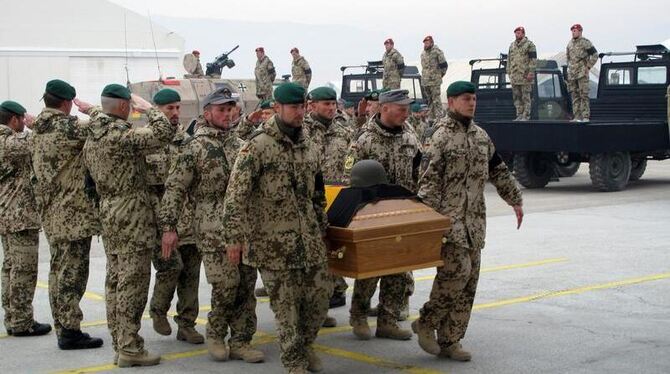 Bundeswehrsoldaten tragen in Masar-i-Scharif einen Sarg in ein bereitstehendes Flugzeug.