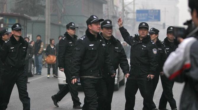 Chinesische Polizisten lösen in Peking eine Menschenmenge auf, nachdem es einen Online-Aufruf zu friedlichen Protestaktionen