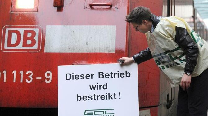 Ein Vertreter der Lokführergewerkschaft GDL lehnt ein Schild mit der Aufschrift »Dieser Betrieb wird bestreikt!« an eine Lok.