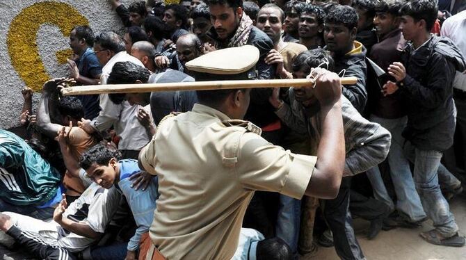 Ein indischer Polizist setzt seinen Schlagstock ein (Archivbild). In Ostindien haben entlassene Arbeiter einen Manager verbra