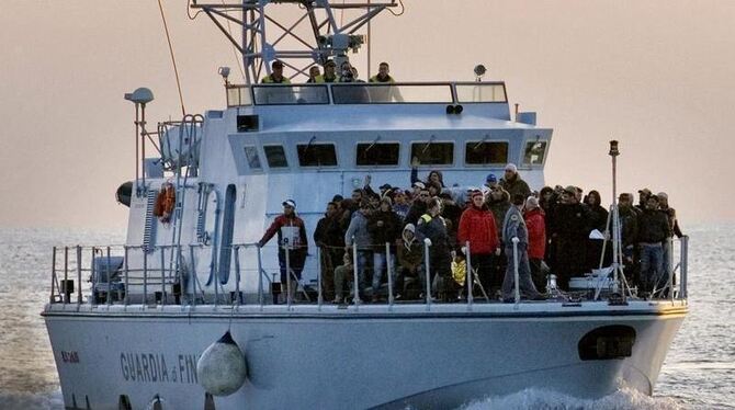 Etwa 70 Flüchtlinge aus Tunesien erreichen auf einem Schiff des italienischen Zolls die Insel Lampedusa.