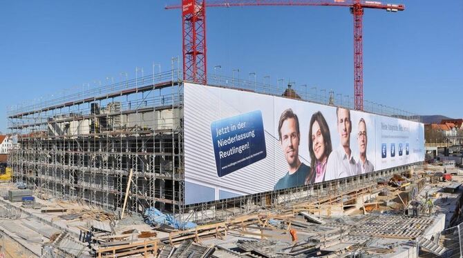 Der zügig wachsende Stadthallen-Bau wird inzwischen vom Baugerüst und einem Werbebanner verhüllt. Dahinter etwas versteckt sind