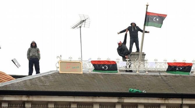 Oppositionelle zeigen die Flagge des Widerstands in Libyen auf dem Dach der libyschen Botschaft in London.