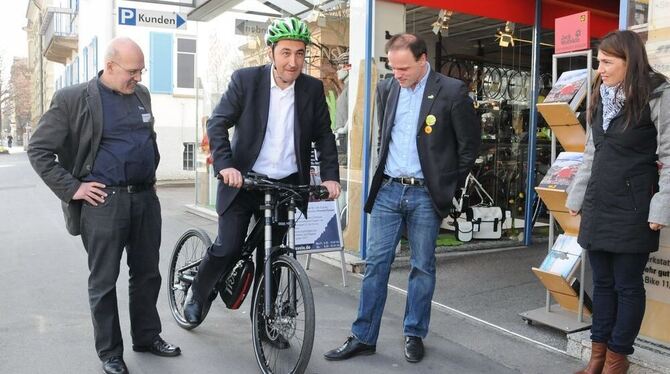 Freude am Fahren: Cem Özdemir startet zu einer Spritztour auf dem Elektro-Bike, assistiert von Christoph Joachim (links) und Tho