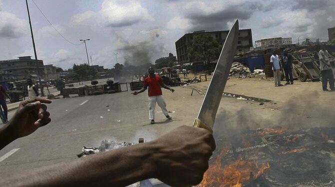 Kampfbereit: In den Straßen von Abidjan bekämpfen sich Anhänger und Gegner des abgewählten Präsidenten.