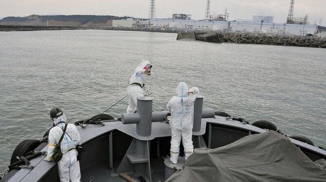 Ein japanischer Schlepper zieht eine U.S.-amerikanische Barge mit frischem Wasser zur Kühlung der Reaktoren an einen Dock des