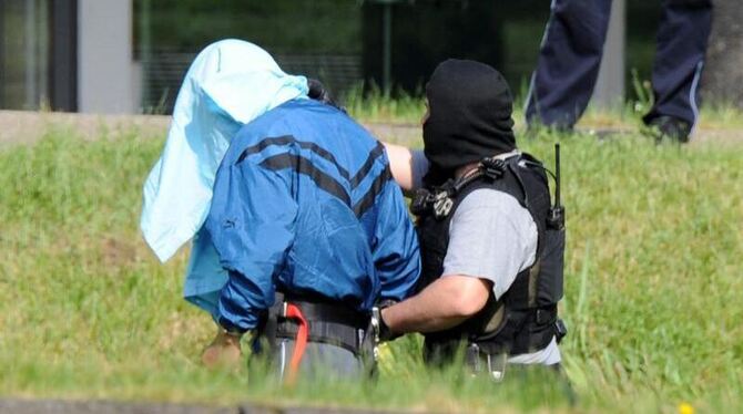 Einer der drei mutmaßlichen Terrorverdächtigen wird auf dem Gelände des Bundesgerichtshofes von Polizeibeamten geführt. 