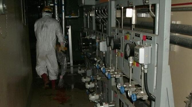 In Schutzkleidung stapft ein Arbeiter durch die Atomruine in Fukushima (Foto vom 9.5.2011).