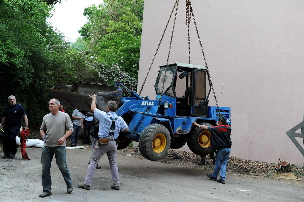 Kran zieht Baumaschine aus dem Neckar