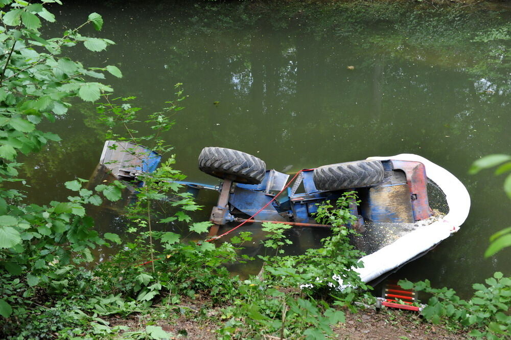 Kran zieht Baumaschine aus dem Neckar