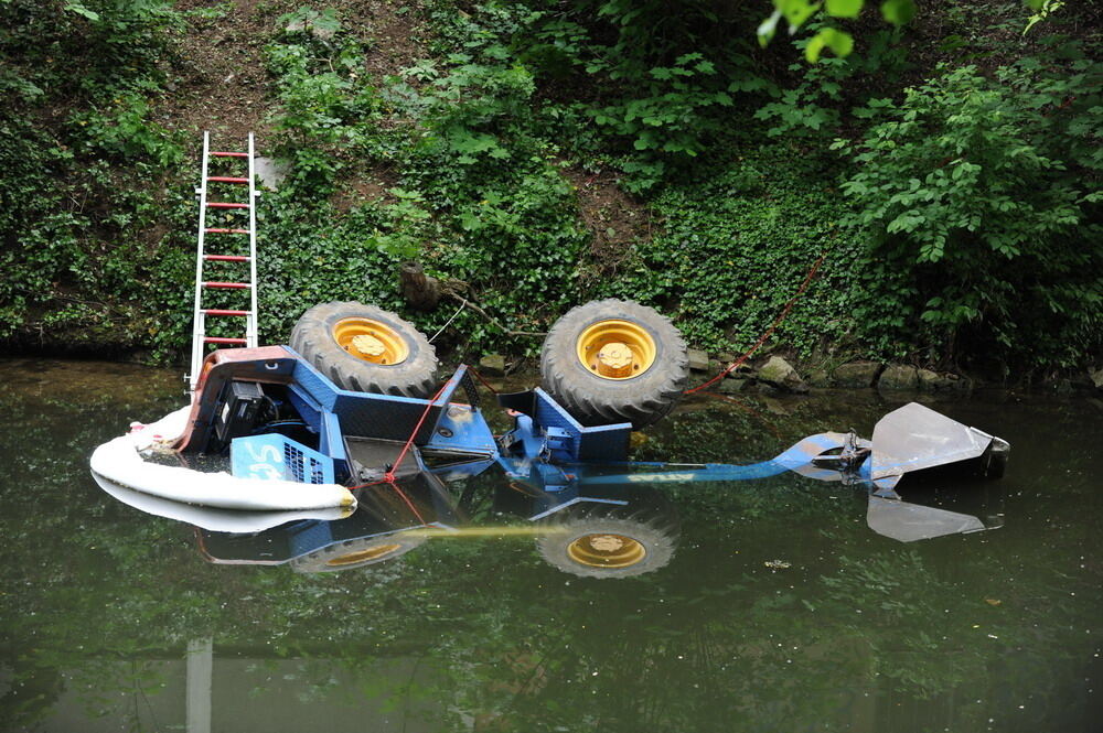 Kran zieht Baumaschine aus dem Neckar