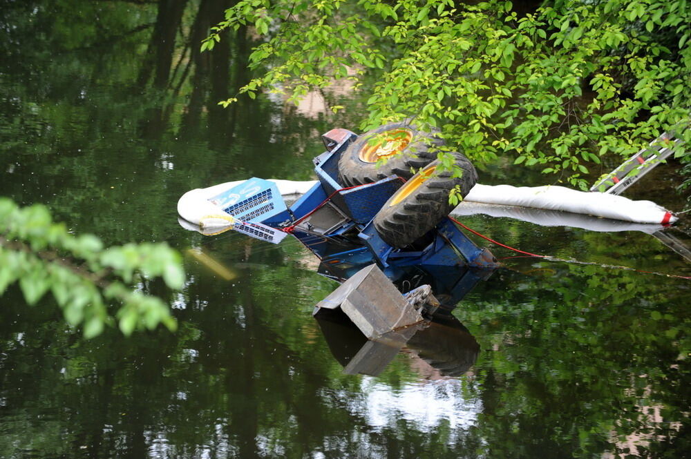 Kran zieht Baumaschine aus dem Neckar