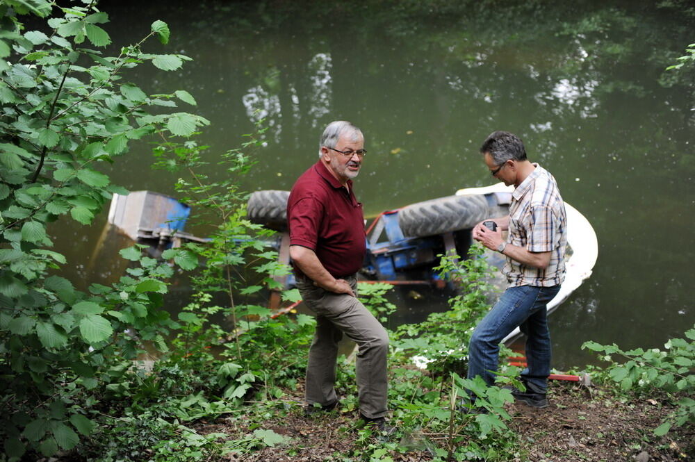 Kran zieht Baumaschine aus dem Neckar