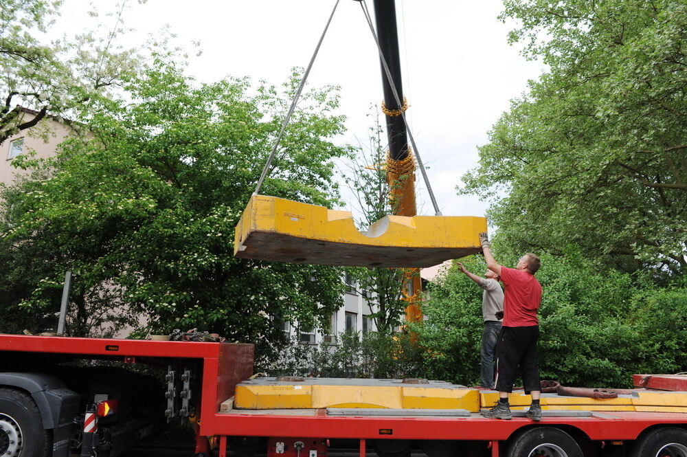 Kran zieht Baumaschine aus dem Neckar