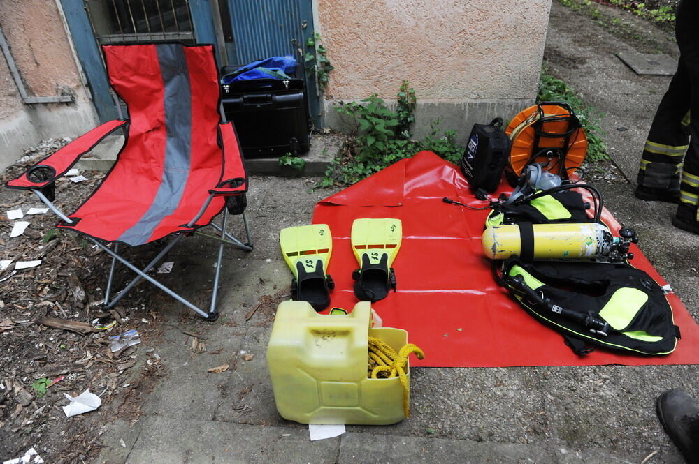 Kran zieht Baumaschine aus dem Neckar