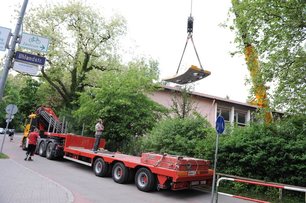 Kran zieht Baumaschine aus dem Neckar