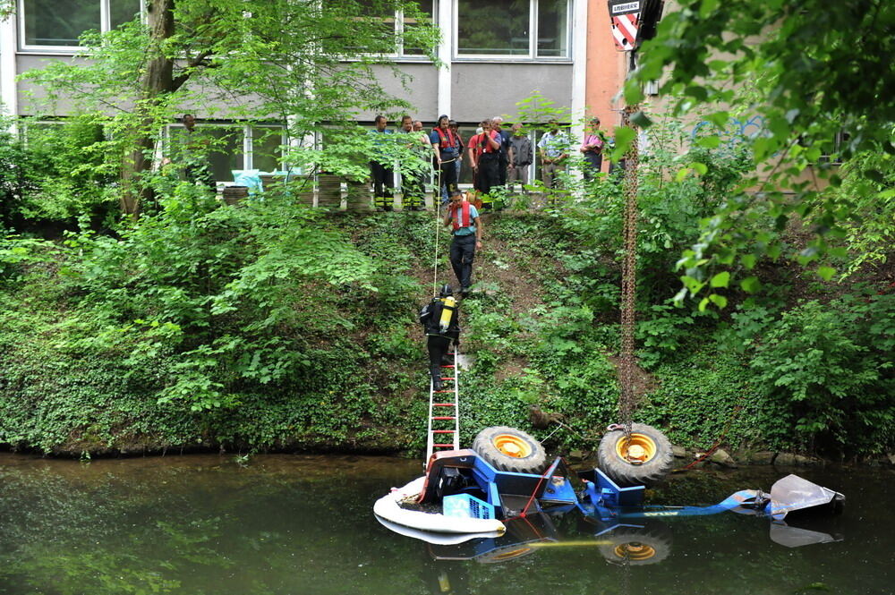 Kran zieht Baumaschine aus dem Neckar