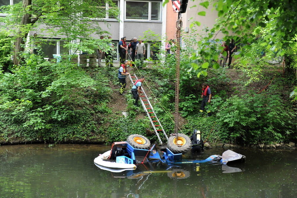 Kran zieht Baumaschine aus dem Neckar