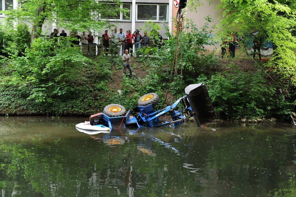 Kran zieht Baumaschine aus dem Neckar