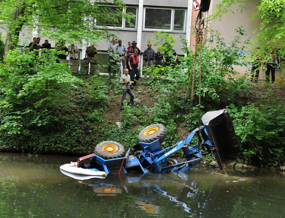 Kran zieht Baumaschine aus dem Neckar