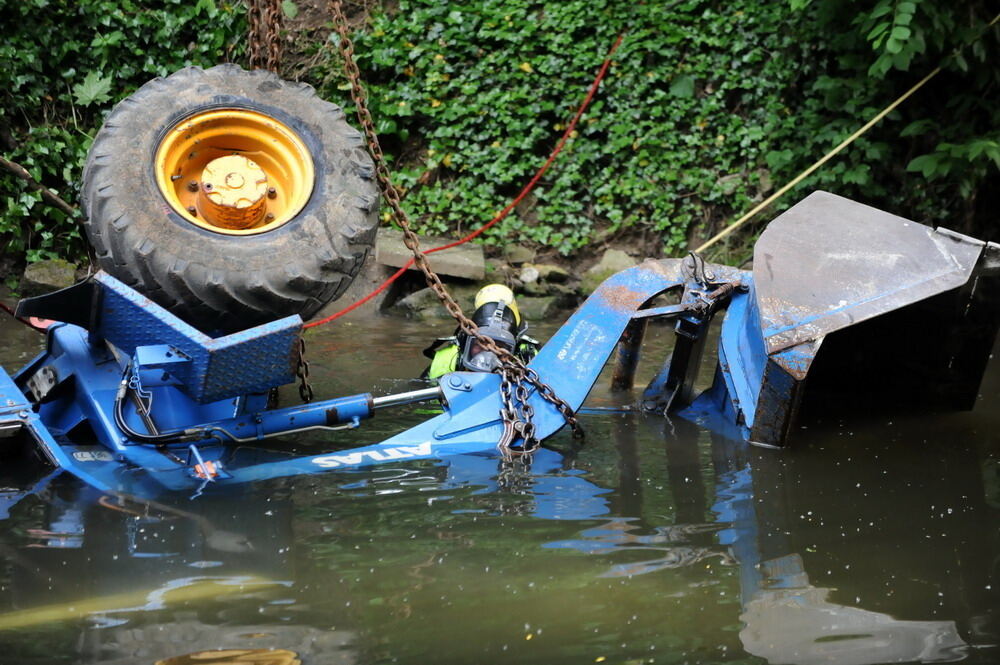 Kran zieht Baumaschine aus dem Neckar