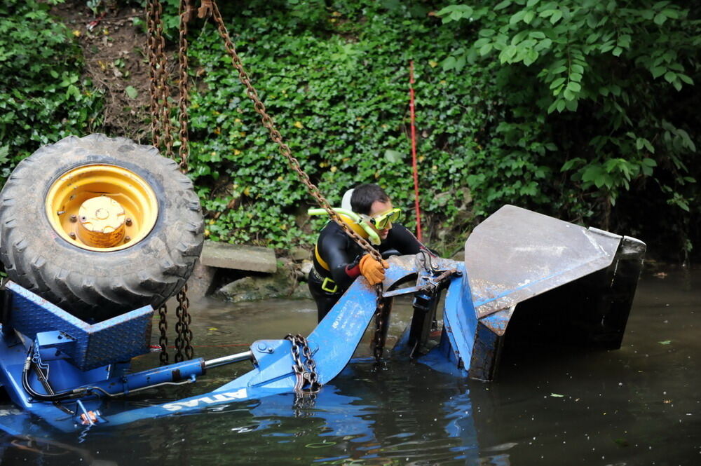 Kran zieht Baumaschine aus dem Neckar