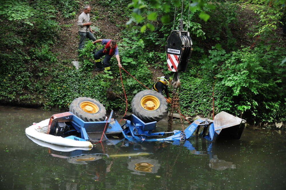 Kran zieht Baumaschine aus dem Neckar