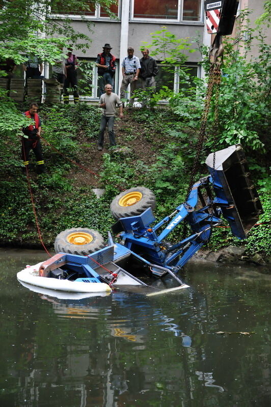 Kran zieht Baumaschine aus dem Neckar