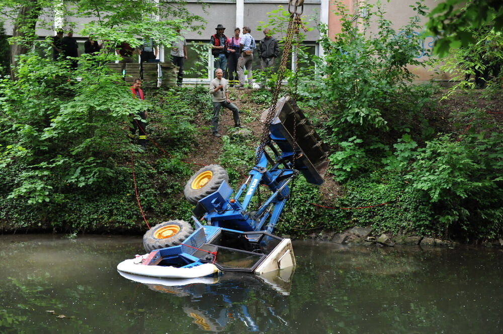 Kran zieht Baumaschine aus dem Neckar