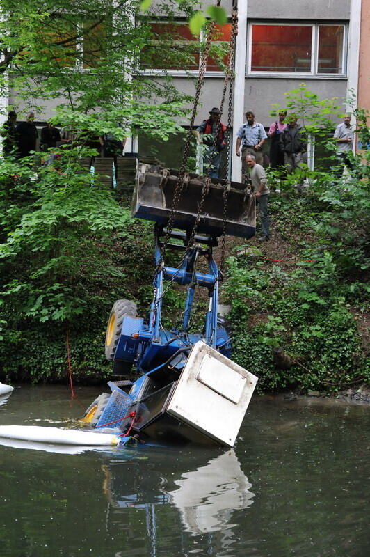 Kran zieht Baumaschine aus dem Neckar