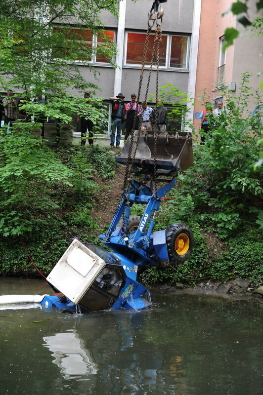 Kran zieht Baumaschine aus dem Neckar