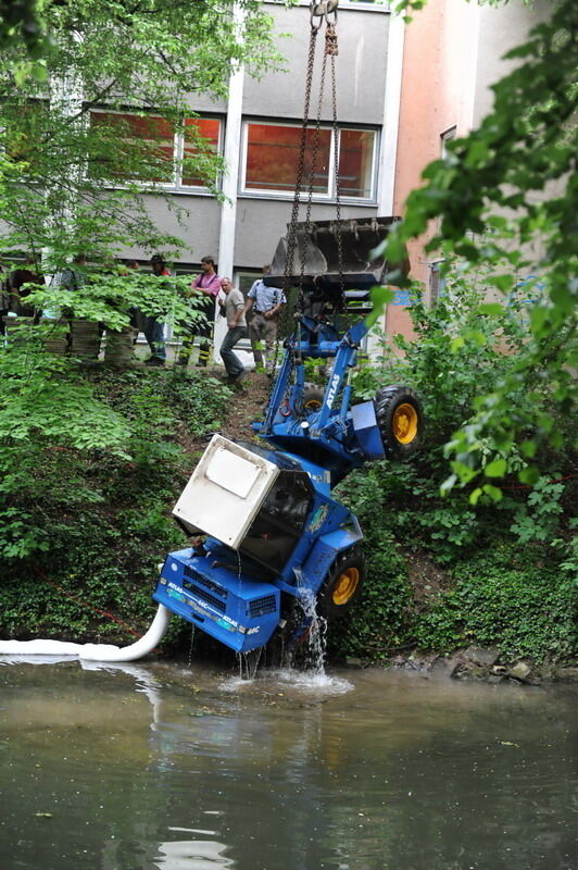 Kran zieht Baumaschine aus dem Neckar