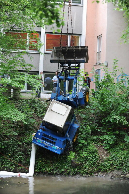 Kran zieht Baumaschine aus dem Neckar