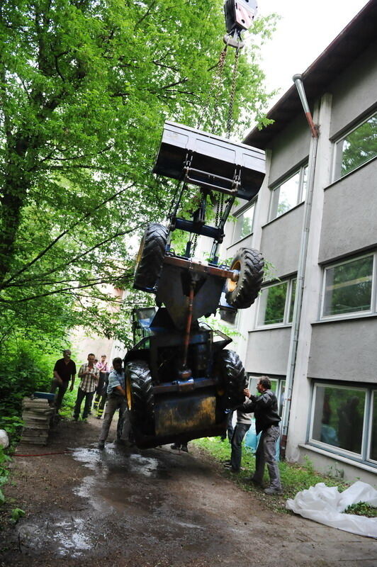 Kran zieht Baumaschine aus dem Neckar