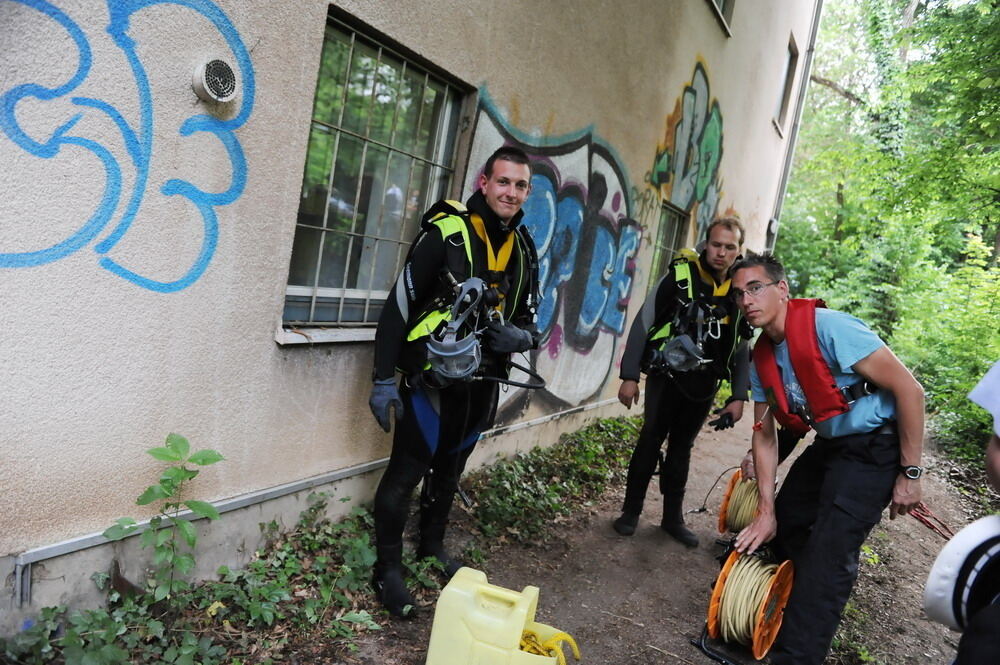 Kran zieht Baumaschine aus dem Neckar