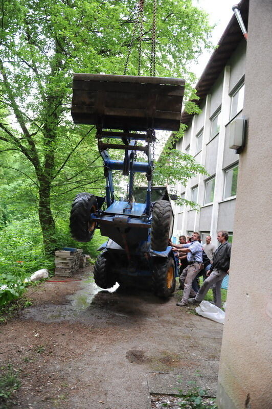 Kran zieht Baumaschine aus dem Neckar