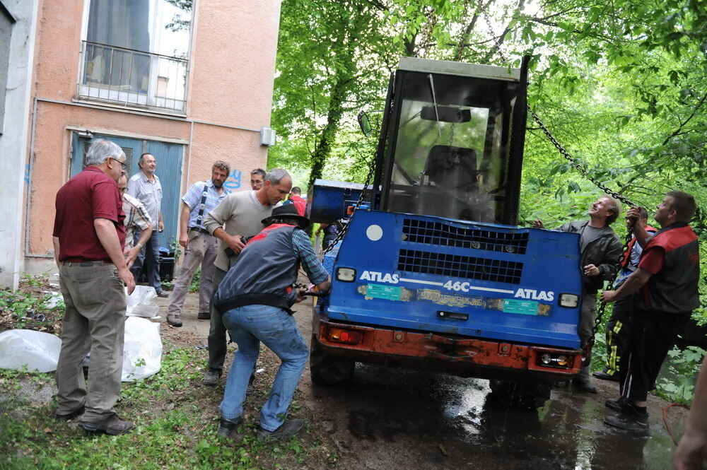 Kran zieht Baumaschine aus dem Neckar