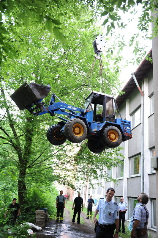 Kran zieht Baumaschine aus dem Neckar