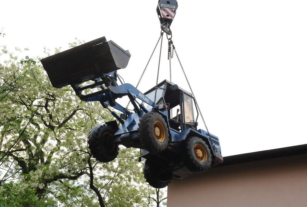 Kran zieht Baumaschine aus dem Neckar