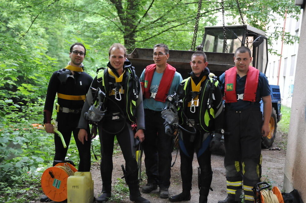 Kran zieht Baumaschine aus dem Neckar